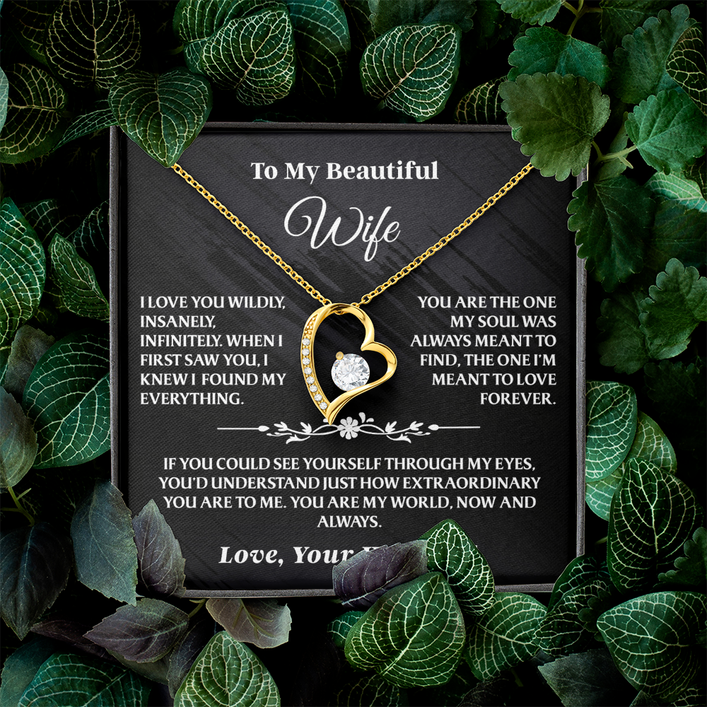 To My Wife - Forever Love Necklace Gift Set - AA38 in gold with heart pendant and message card, beautifully displayed among green leaves.